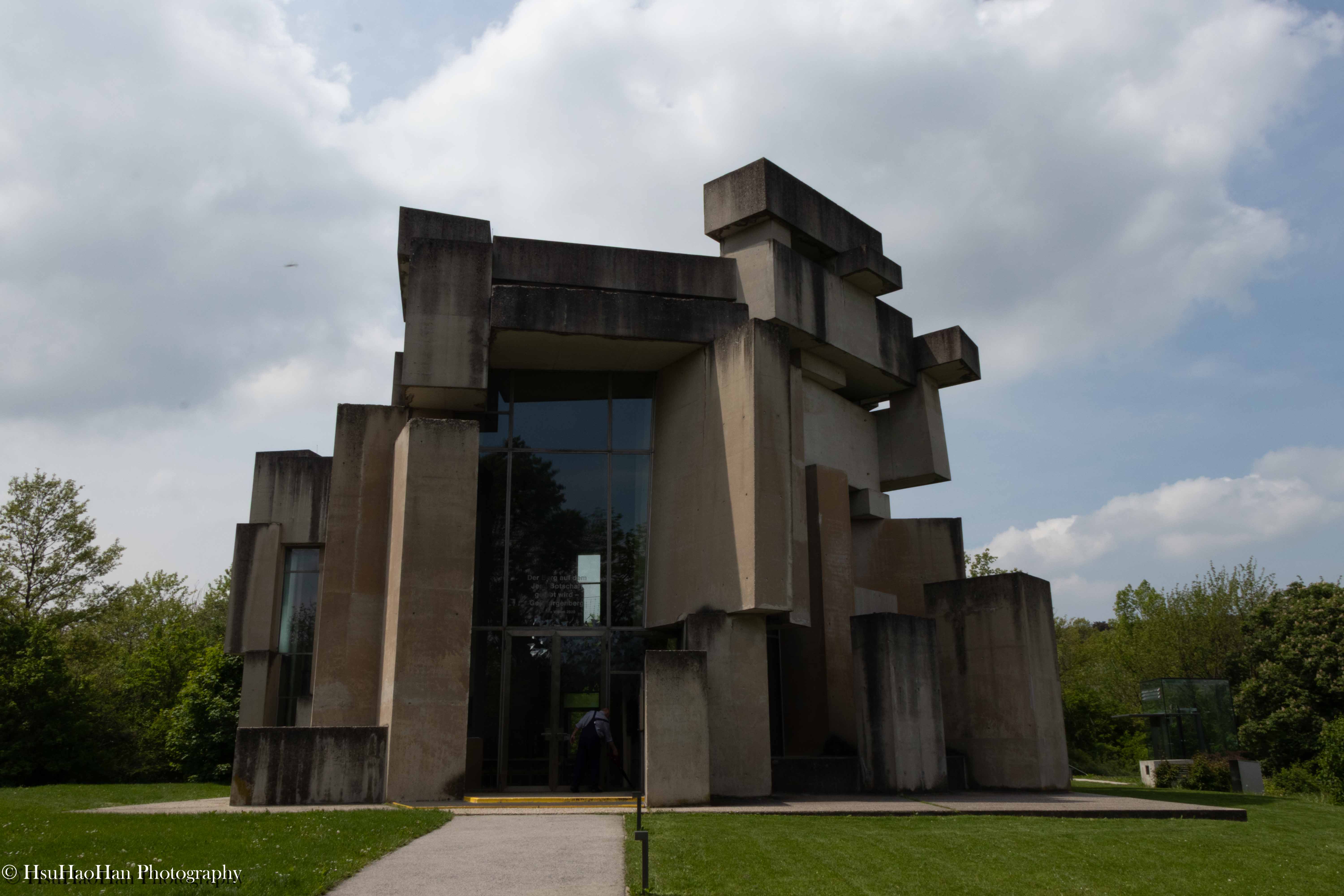奧地利維也納沃特魯巴教堂的入口路徑，視線朝向由巨大混凝土塊構成的粗獷主義建築。