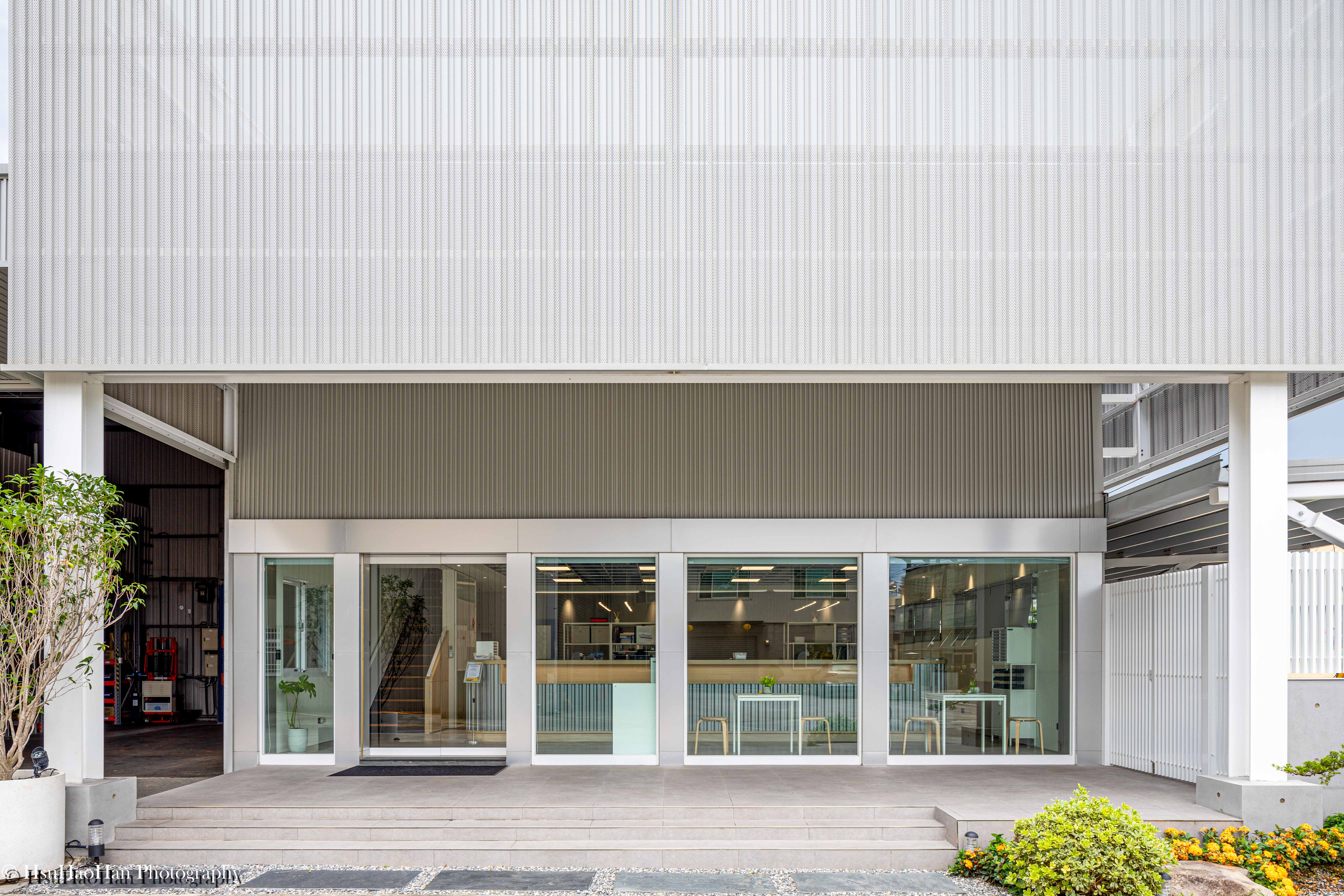 Minimalist glass entrance and white perforated steel cladding detail at Yiguan Steel office - 誼冠鋼品辦公室入口落地玻璃與白色金屬沖孔板細節 - Photography by Hsu Hao Han
