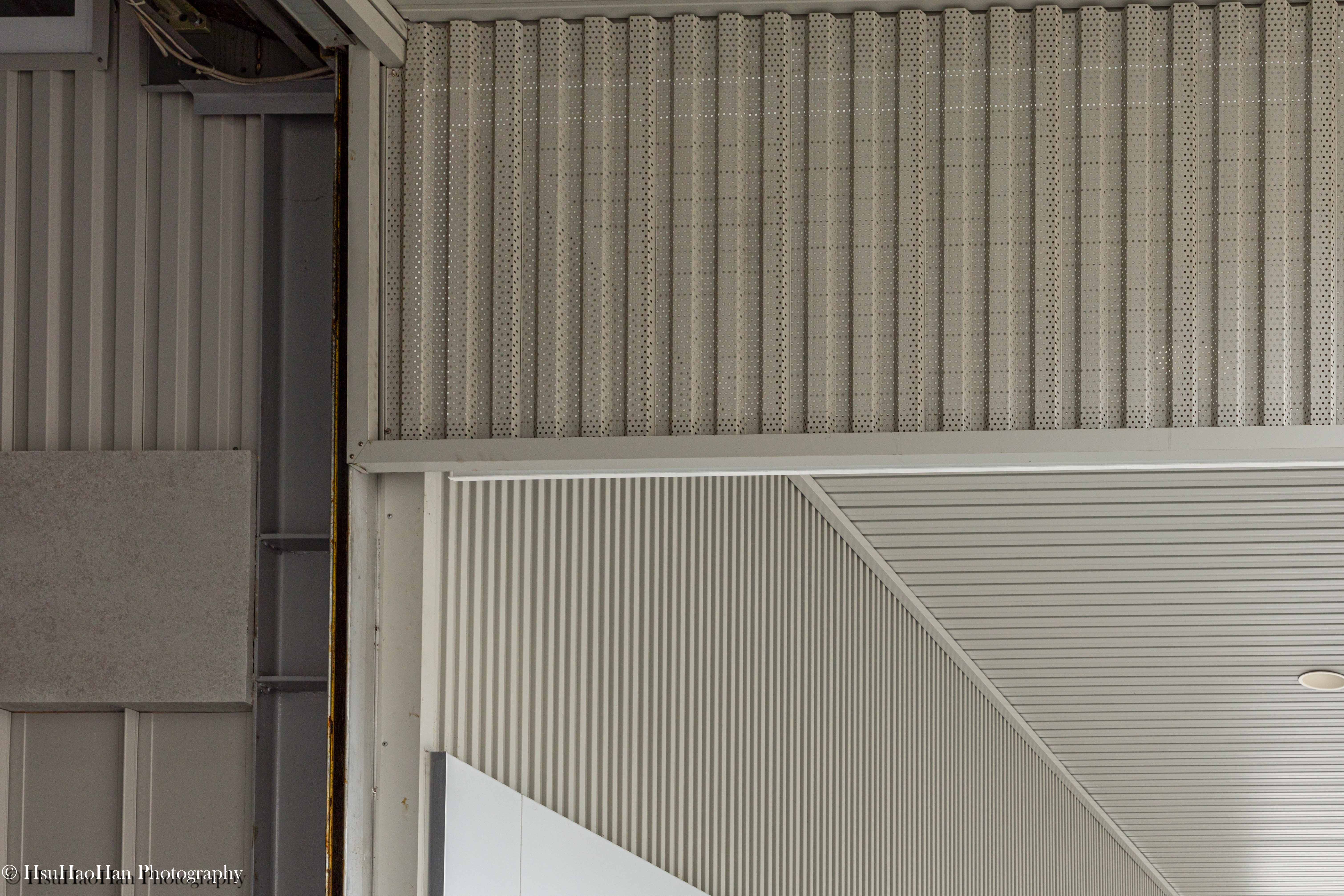 Detail contrast between white perforated metal screen and grey corrugated siding on factory facade - 誼冠鋼品建築外觀白色金屬沖孔板與灰色浪板建材拼接細節 - Architectural Photography by Hsu Hao Han
