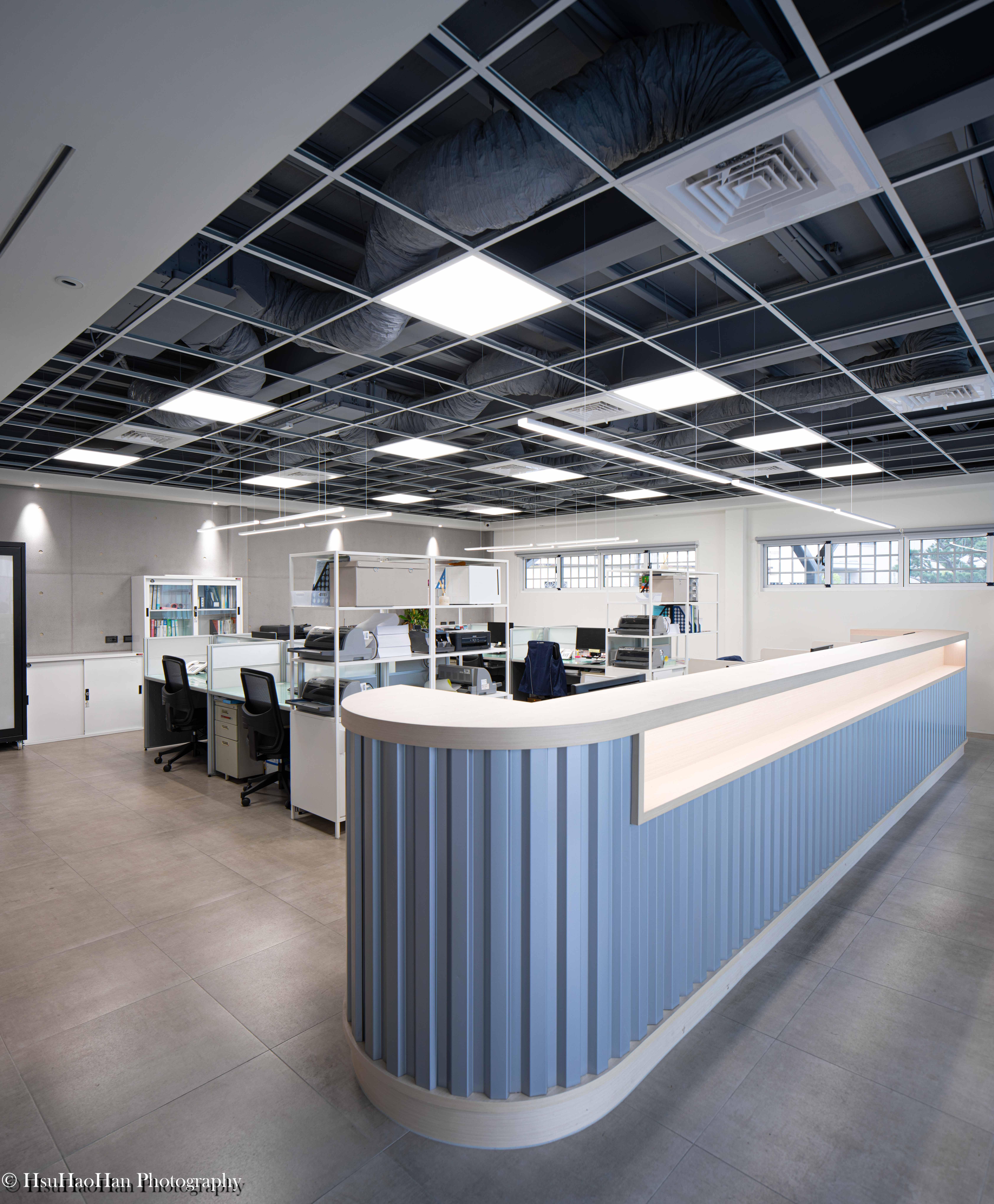 Open plan office interior with exposed ceiling ducts and corrugated metal reception desk - 誼冠鋼品辦公室內部設計工業風裸露天花板與浪板櫃台 - Photography by Hsu Hao Han