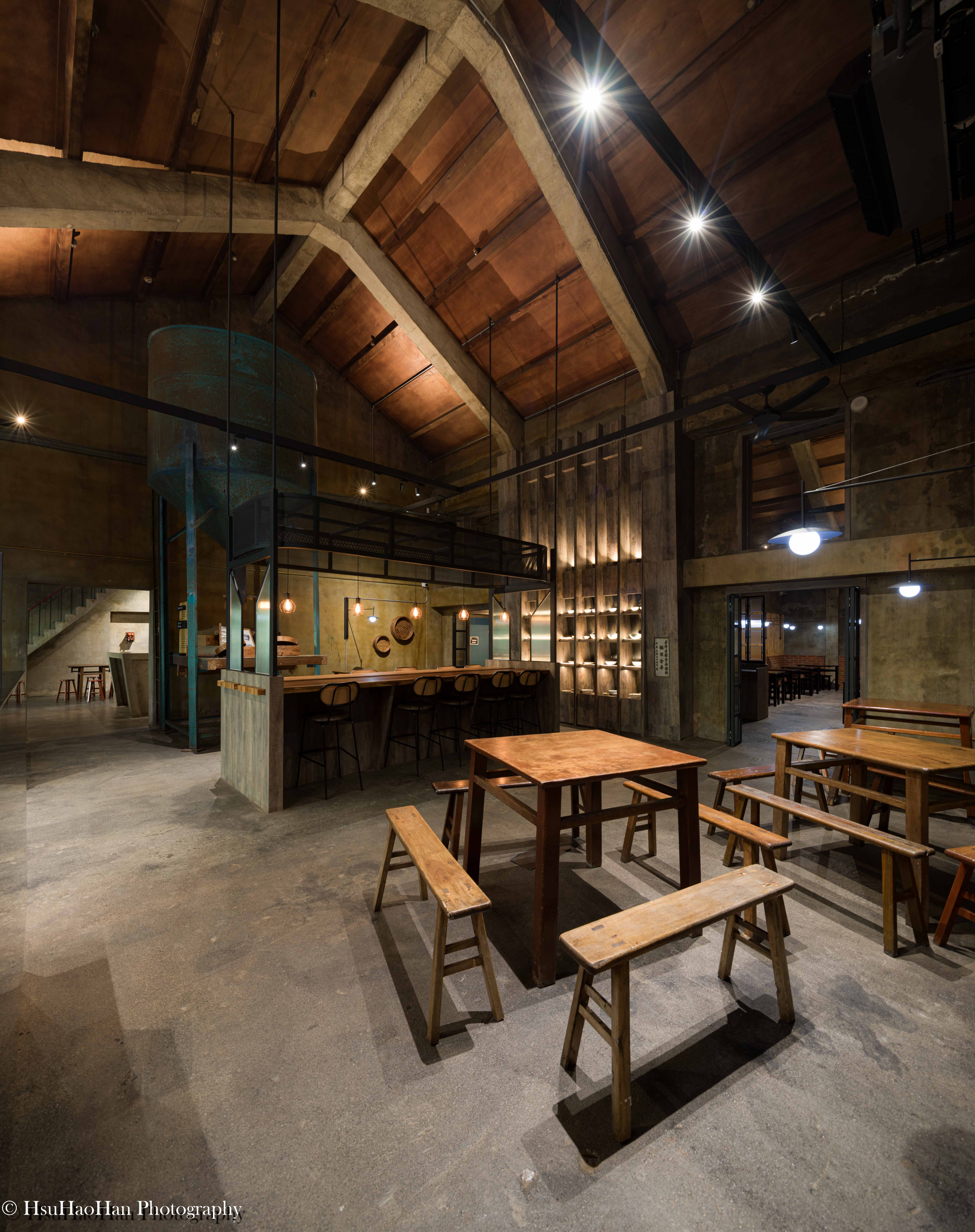 Interior of renovated barn restaurant featuring exposed original wooden trusses and industrial atmosphere - 國姓鄉農會文創園區農民食堂內部保留原有木造桁架結構與工業風空間 - Photography by Hsu Hao Han