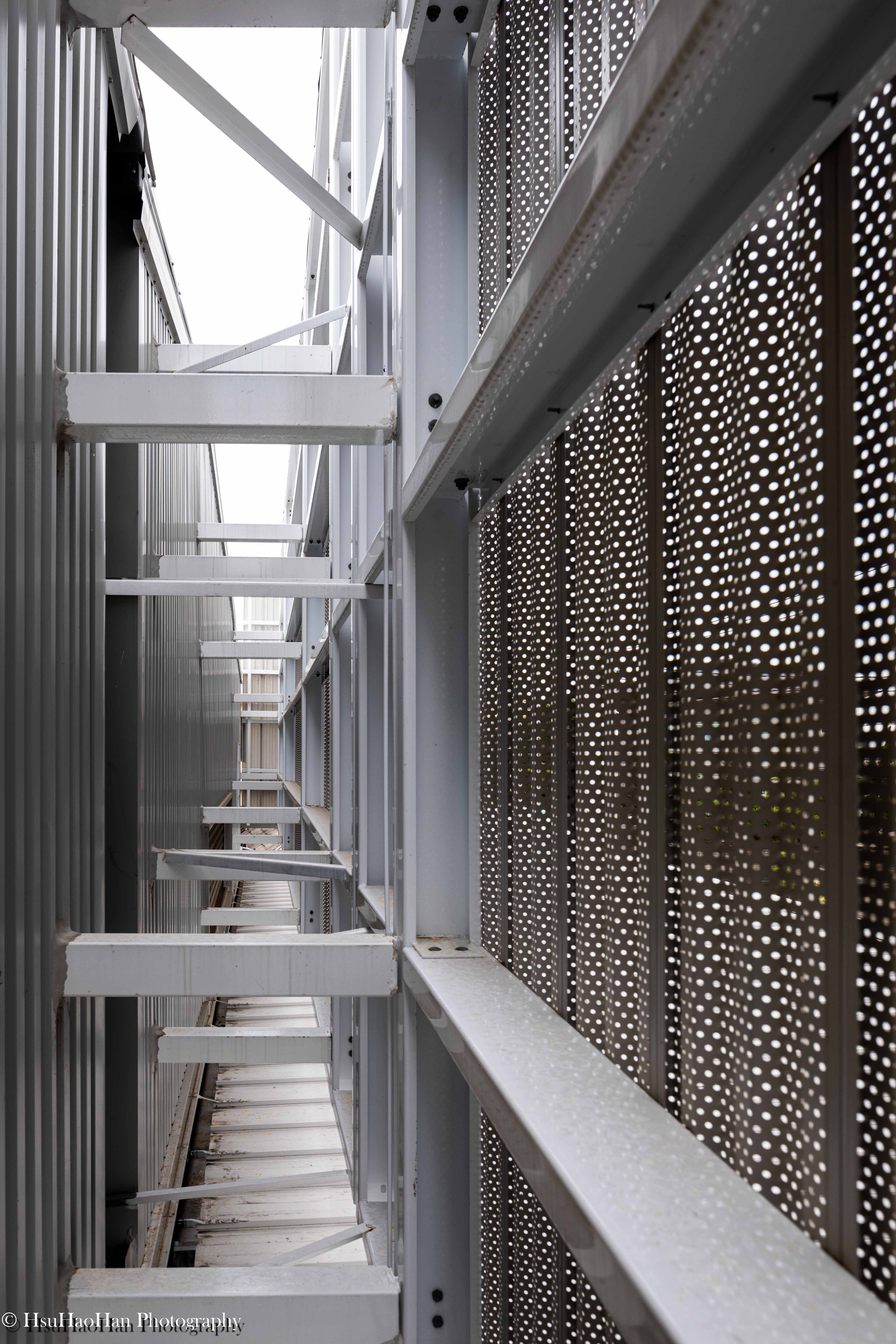 Structural detail of steel beams and perforated metal screen mounting system - 工業建築雙層表皮鋼構骨架與金屬沖孔板固定工法特寫 - Architectural Photography by Hsu Hao Han