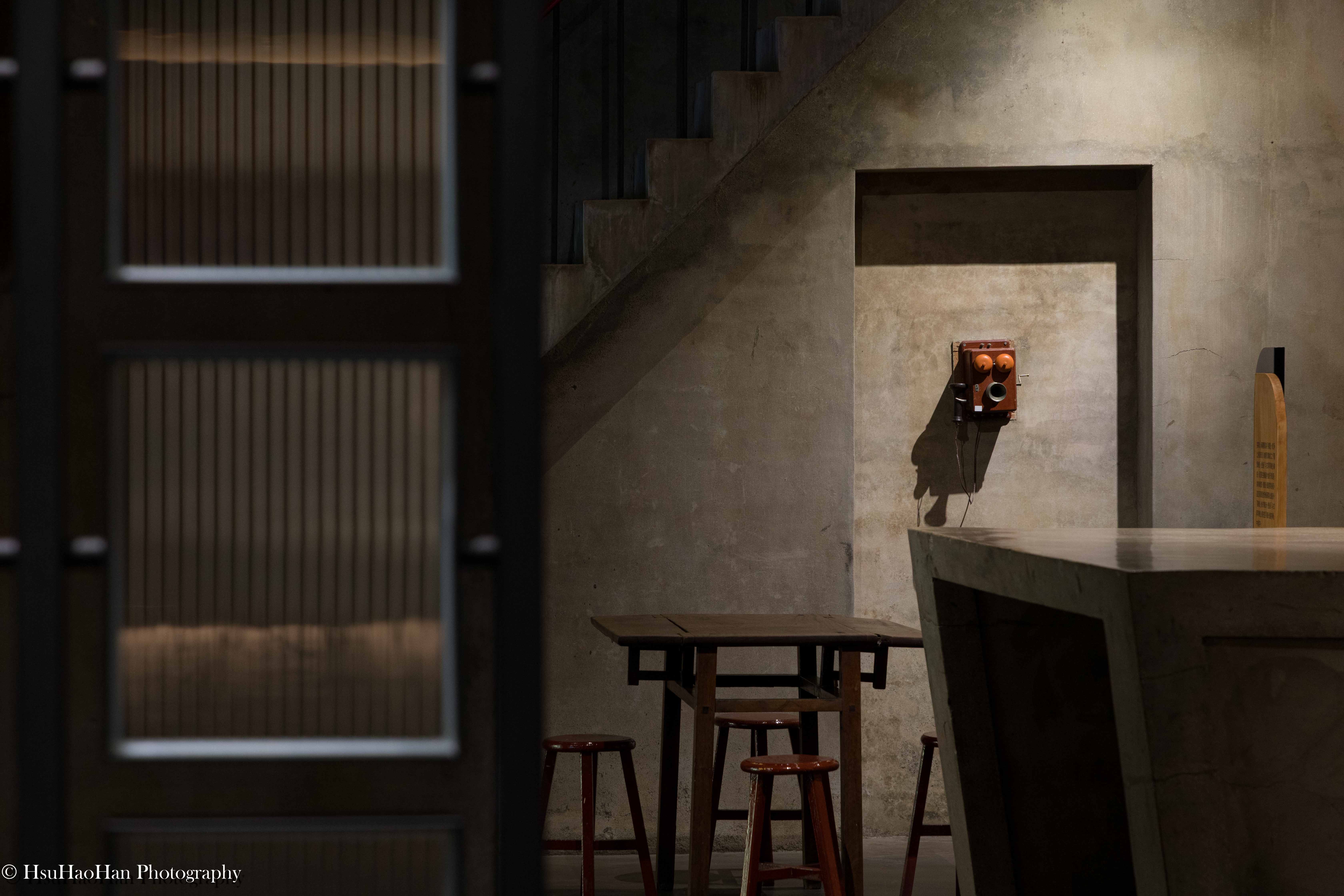Vintage orange telephone mounted on concrete wall with moody lighting at Guoxing Cultural Park - 國姓鄉農會文創園區復古橘色電話與清水模牆面氛圍攝影 - Photography by Hsu Hao Han