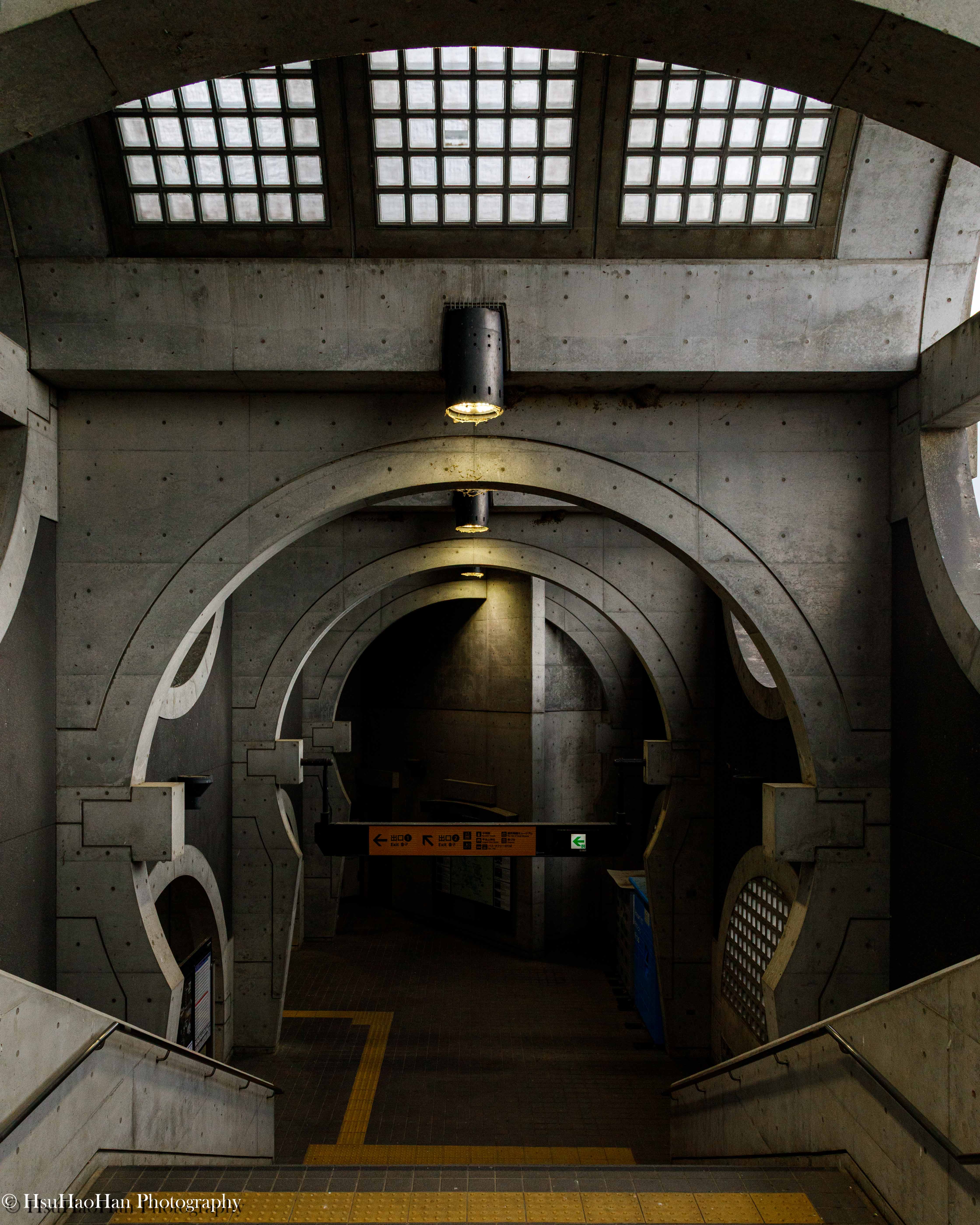 宇治車站的樓梯間，展現了若林広幸設計中重複出現的圓拱形混凝土開口，光影對比強烈，充滿戲劇張力。