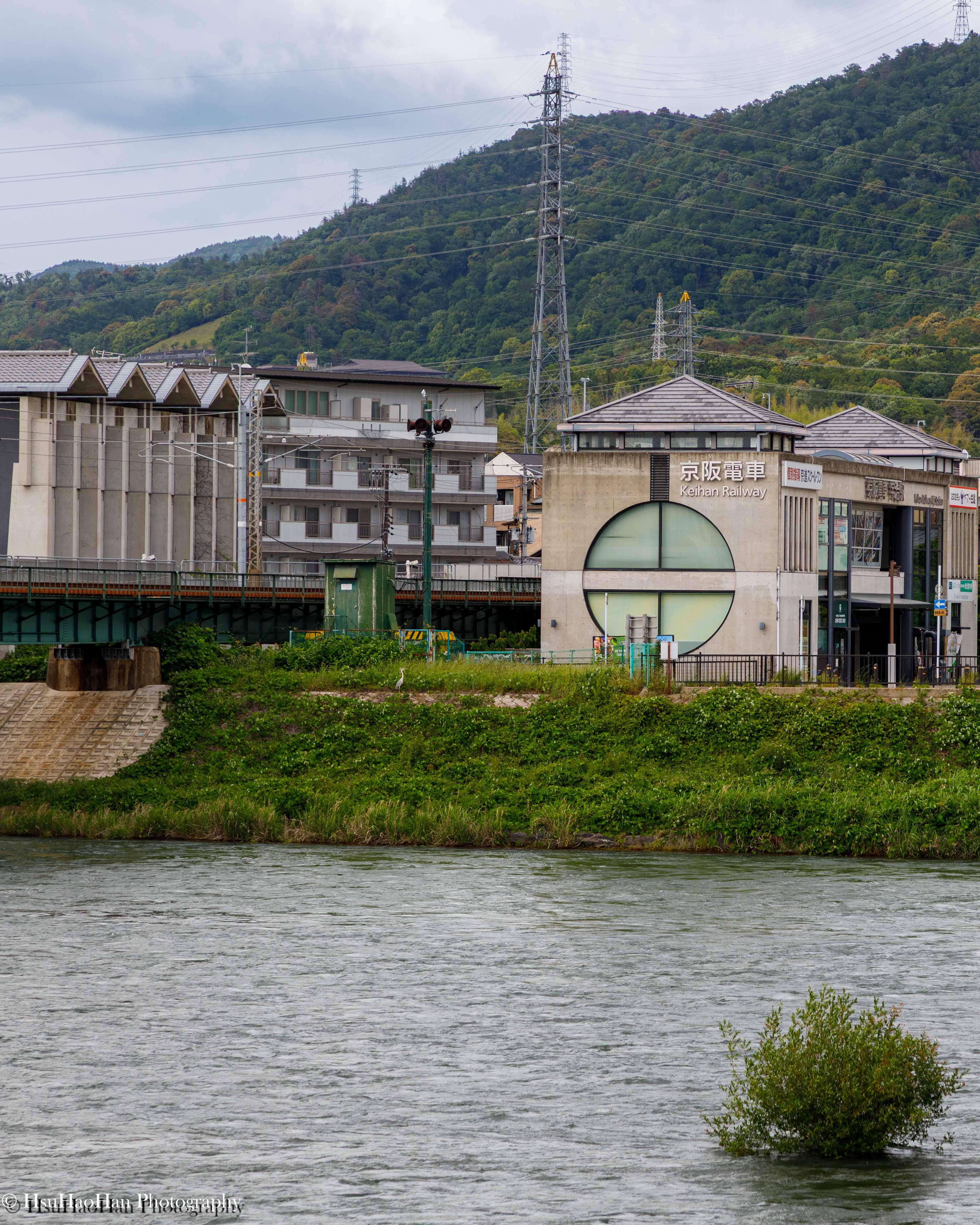 從宇治川對岸遠眺由若林広幸設計的日本宇治車站，其獨特的清水混凝土結構與圓形開口，融入河岸的自然景觀中。