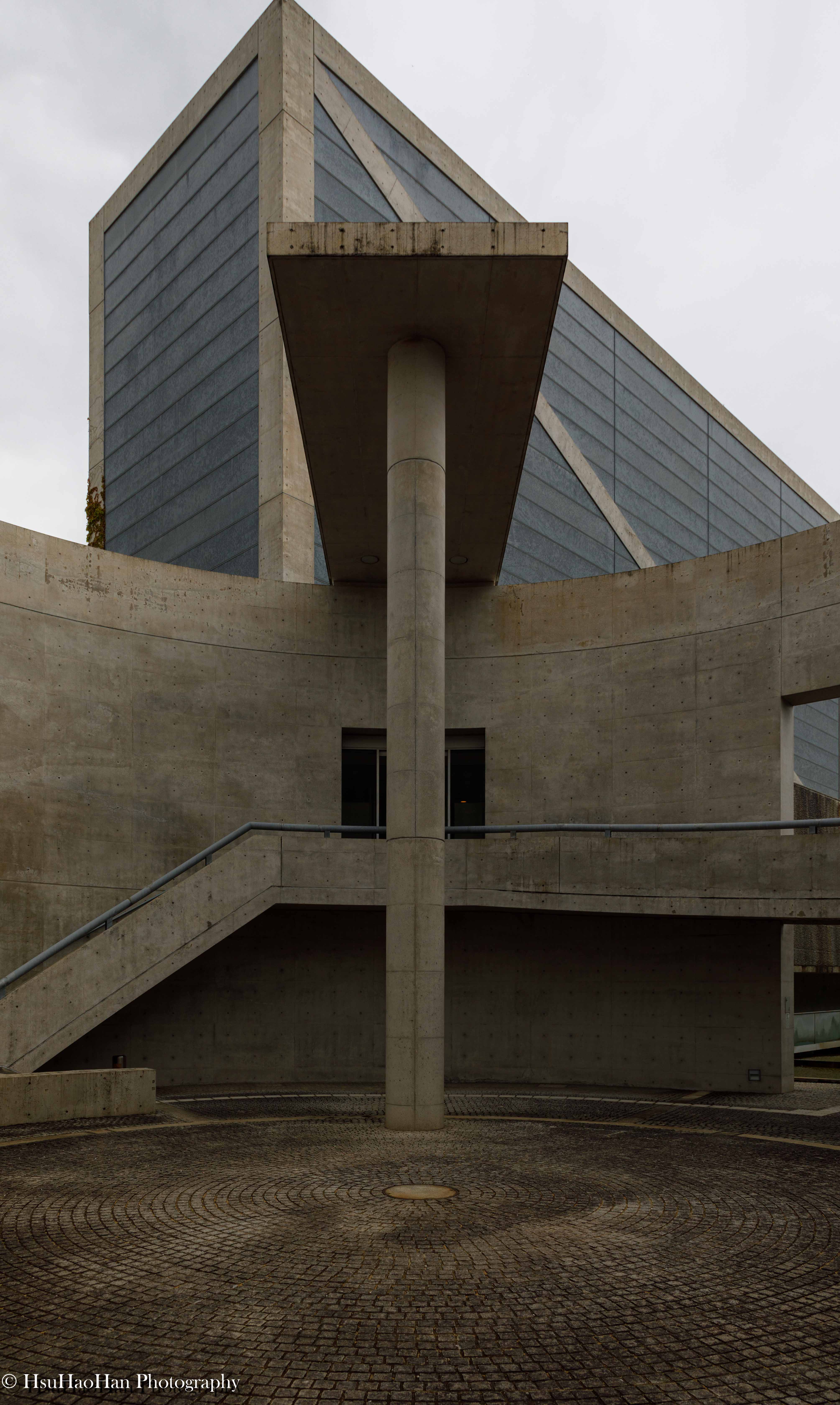 安藤忠雄設計的大阪狹山池博物館入口水庭，清水混凝土牆面環繞著線性的淺水池，營造出寧靜而富有儀式感的空間序列。